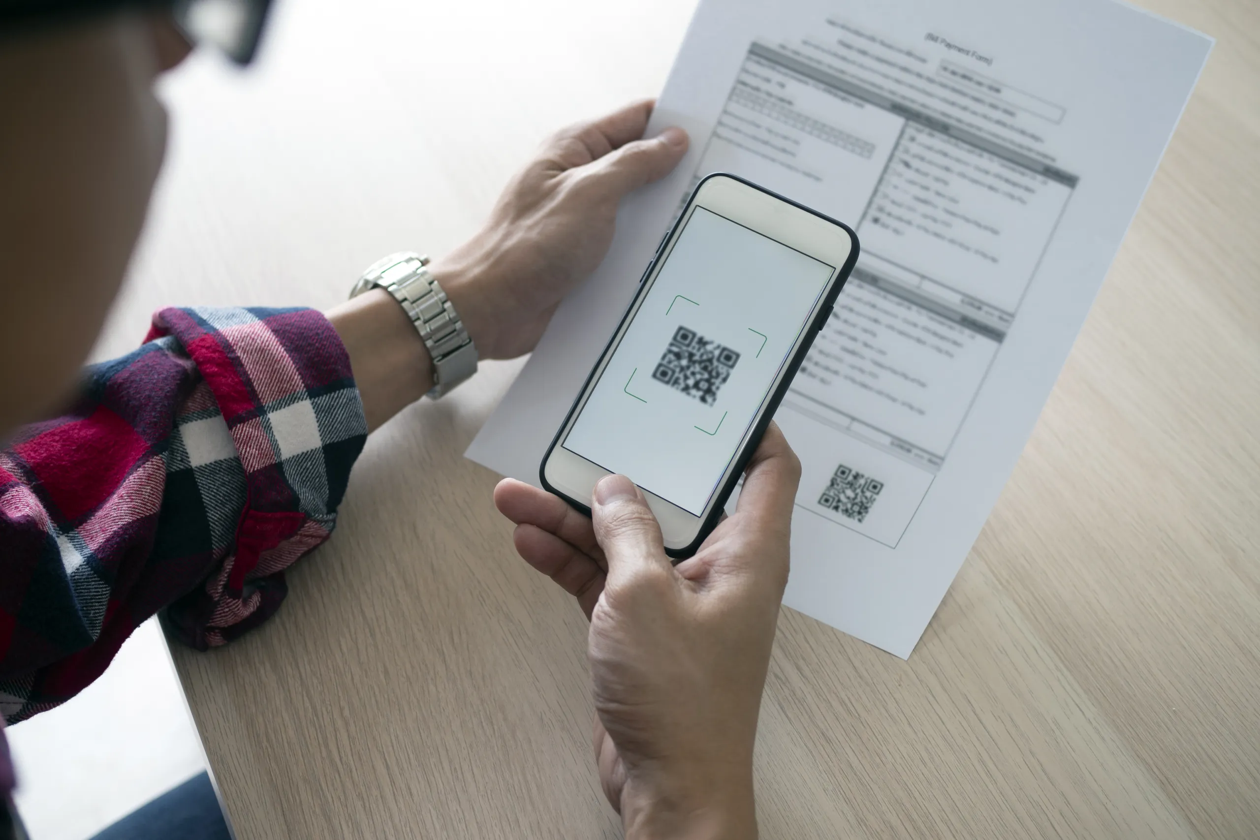 man-uses-smartphone-scan-qr-code-pay-monthly-credit-card-bills Faturas com QR Code e ACTUD